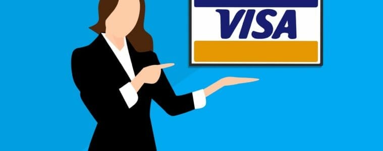 A woman in a suit standing next to the Visa logo. Image by Mohamed Hassan on Pixabay.