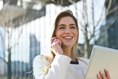 Woman in white blazer holding tablet computer. 1 in 7 Irish Businesses Report Having No Women in Senior Management