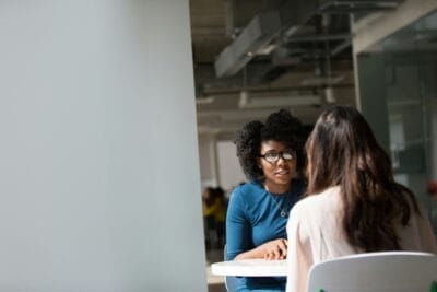 Woman wearing blue top beside table. National Women’s Enterprise Day for 2025 Announced